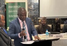 Attorney General Advocates Robust Regional Justice System at ECOWAS Judicial Council Panel of officials at a formal meeting, with a banner behind them reading ECOWAS, the man in a blue suit speaking into a microphone beside others.