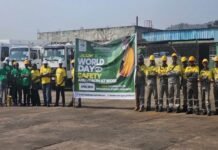 NP(SL) Commemorates World Day for Safety and Health at Work with Focus on Psychosocial Wellbeing Group of workers in yellow and green uniforms with hard hats standing in a line beside a banner that reads World Day for Safety and Health at Work (2026).