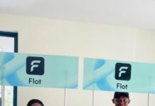 Open Hubb Launches ‘Flot’ Platform to Boost Financial Inclusion in Sierra Leone Two staff members in turquoise shirts stand behind Flot promotional counters with teal branding on display boards above them.
