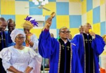 BCSL Installs Rev. Dr. Samuel G.A. Kargbo as New Executive President, Hails Outgoing Leader Rev. Dr. Joseph Fornah Clergymen in blue robes participate in a ceremony; a man raises a wooden gavel while a speaker with a microphone stands nearby.