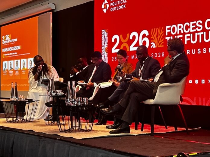 Panel discussion on stage with five speakers seated in white chairs against a red backdrop reading 2026 Forces of the Future Russia poster