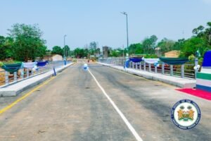 Newly inaugurated bridge decorated with blue and white bunting and balloons for a ceremonial opening; official seal in foreground.
