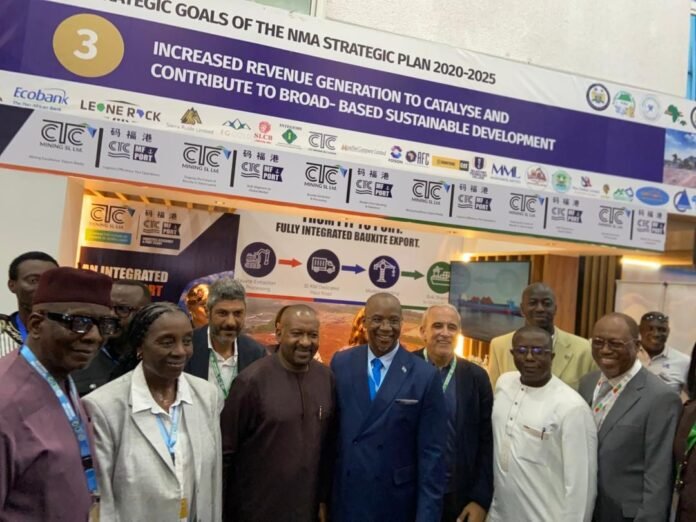 Group of officials posing in front of a trade show booth promoting the NMA Strategic Plan 2020–2025