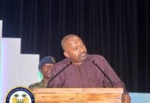 Vice President Launches Critical Minerals Strategy, Seeks Greater Value from Mining Sector Man speaks at a wooden podium on stage, with a uniformed guard behind and an official seal in the foreground left.