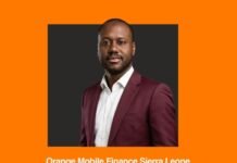 Orange Mobile Finance Sierra Leone Appoints Mahamane Sidi Touré as Chief Executive Officer Portrait of a man in a burgundy suit against an orange background; caption: 'Orange Mobile Finance Sierra Leone appoints New Chief Executive Officer'
