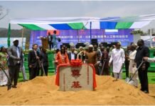 Ambassador Zhao Yong Highlights 40 Years of Fisheries Cooperation and Growing Trade Officials and locals gather around a ceremonial stone on a sand mound at a port groundbreaking under a white-and-blue canopy.