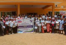 WAYCAN Concludes Agro-Fish Farming Training for 250 Youths in Makeni Large group of men and women holding certificates in front of an orange building during a workshop on agro-fish farming.