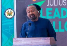 Vice President Applauds President Bio’s Commitment to Inclusive Leadership and National Development Man in a blue traditional outfit speaks at a wooden podium with a microphone, an official seal to his left and a backdrop with 'LEAD' text behind him, during an event.