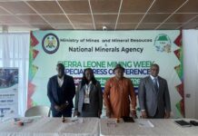 As Mines Minister Pushes for Responsible Resource Management… Sierra Leone Mining Week 2026, 11th ADPA Meeting Begin Today in Freetown Four professionally dressed individuals stand behind a long, white-clothed table in a conference setting, with a large banner reading 'Ministry of Mines and Mineral Resources & National Minerals Agency' in the background and microphones on the table in front of them.