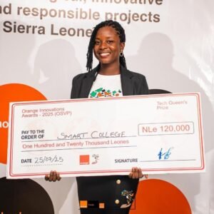 Smiling woman in a blazer holding a large ceremonial check for Smart College at the Orange Innovations Awards 2025 on stage