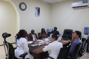 Group of professionals around a conference table in a bright office, reviewing documents and talking.
