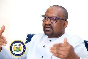 Man in white attire and glasses speaks, gesturing with his hands; official government seal of the Office of the Vice President on his chest.