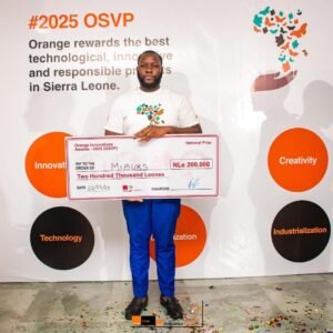 Man holding an oversized cheque for Two Hundred Thousand Leones at a #2025 OSVP event; backdrop shows orange circles with Innovation, Creativity, Technology, and Industrialization labels.