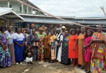 Theological Consortium Sierra Leone Holds First-Ever Women-to-Women Bible Conference in Bo Group of women (and a small child) posing for a photo outdoors in colorful traditional dresses, in front of a building.