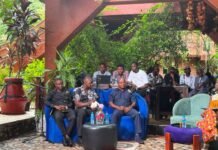 SHE4Peace Champions Men’s Mental Health, Calls for Inclusive Approach to Gender Equality Group of men seated for an outdoor panel discussion under a wooden canopy, microphones and laptops in front, greenery in the background.