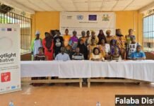 WFSL Concludes One-Week Capacity Building Training Across Three Districts Under Spotlight Initiative 2.0 Group of men and women posing for a photo at a community event with a Spotlight Initiative banner in the background, Falaba District.