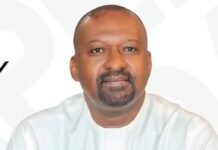 VP Juldeh Jalloh Wins Praise for Quiet Leadership and Unflinching Loyalty Portrait of Hon. Dr. Mohamed Juldeh Jalloh in a white traditional outfit, hands folded, Vice President of Sierra Leone (text on shirt)