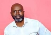 Autopsy Report Raises Questions Over Death of APC Stalwart Abdul Rahmadan “Omega” Sesay Man with a gray beard and light blue shirt posing against a pink background.