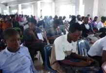 Elite Scholars Consultancy Hosts Educational Seminar at Central University Large hall filled with students seated in rows, many with backpacks and laptops, waiting for an event.