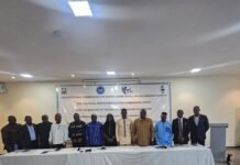 ECSL Chairman Urges Universities to Drive Democratic Governance Education Group of officials standing behind a long table in a conference room, with an Electoral Commission banner behind them.