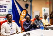 SLAJ Concludes Two-Day AGM with Renewed Commitment to Press Freedom & Responsible Journalism Four men sit at a conference panel table, with banners and a water bottle visible in the background.