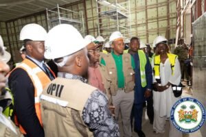Group of people in hard hats and safety vests inspecting a construction site; official seal of the Office of the President visible in the corner.