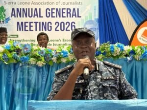 | The Calabash Newspaper Police officer in uniform speaks at a podium during the Sierra Leone Association of Journalists AGM 2026.