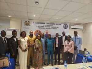Group of professionals posing for a photo at a stakeholder consultative meeting, banner behind them about railway masterplan development.