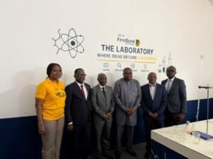 Six professionals pose in a lab area beside a sign that says FirstBank The Laboratory: Where Ideas Become Discoveries.