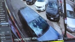 CCTV footage of a blue van parked on a street with other cars along the curb, labeled 'FRONT STREET VIEW' on the screen.