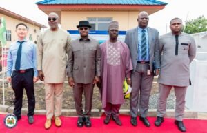 | The Calabash Newspaper Six men in formal and traditional outfits pose on a red carpet outdoors for a group photo outside a building.
