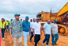 As Government Urged to Honour Financial Commitment… High-Level Government Delegation Hails Gento Group’s US$75 Million Kent Port Project Group of men walking on a dirt construction site beside a large orange excavator, some in safety vests and hats.