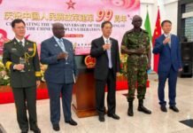 China Celebrates PLA’s 99th Anniversary, Reaffirms Strong Military Partnership with Sierra Leone Six men in military uniform and suits toast with raised glasses at a ceremony celebrating the 99th anniversary of the Chinese People's Liberation Army, with a pink banner and flags in the background.