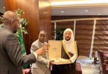 Sierra Leone, Saudi Arabia Deepen Cooperation in Islamic Affairs Three men in a formal room exchange a gift bag as others look on.