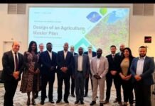 Vice President Concludes High-Level France Mission, Strengthens Investment and Development Cooperation Twelve professionals in business attire pose for a group photo in a conference room; a presentation slide behind them reads 'Design of an Agriculture Master Plan' with 'Paris — July 2019' and 'Republic of Sierra Leone' visible.