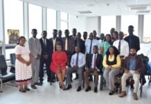 Audit Service Sierra Leone Inducts 22 New Staff to Strengthen Public Sector Auditing Diverse group of professionals posing for a group photo in a bright office conference room.