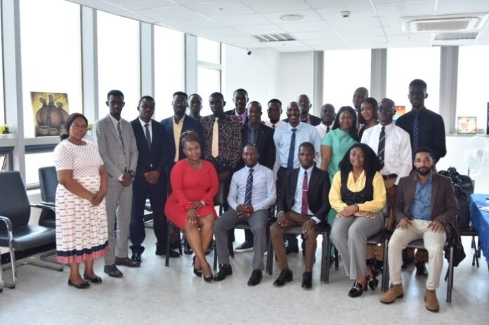 Diverse group of professionals posing for a group photo in a bright office conference room.