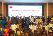 China, Sierra Leone Celebrate 55 Years of Diplomatic Relations and Enduring Partnership Group photo on a stage at a cultural gala celebrating 55 years of China–Sierra Leone diplomatic relations, with a banner and a Chinese flag in the background.