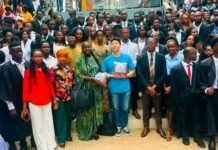 Central University Graduates 200 Students Under Ready Salone Project Large diverse group of graduates and attendees posing for a photo on a staircase, with a person in a blue shirt holding books at the center.