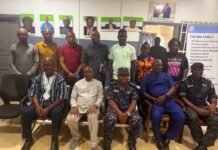 Internal Affairs Minister Meets Bike Riders Union Over Lawlessness and Public Safety Group of adults posing for a formal photo in an office, with portraits on the wall and a banner to the right.