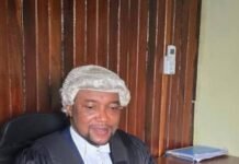 Principal Magistrate Hadiru Daboh Commits 18 Kailahun Suspects to High Court Male judge in black robes and a white wig sits at a desk in a wood-paneled office, hands clasped on the desk.