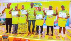 Group of people on a yellow-themed stage holding certificates at an ONGA event, posing and smiling for the camera.
