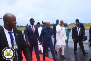 Group of dignitaries walking on a tarmac beside a red carpet; official seal of the Office of the Vice President visible in the bottom-left corner.