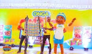 Colorful stage with an ONGA mascot in a yellow apron celebrating at a product event; confetti and banners in the background.