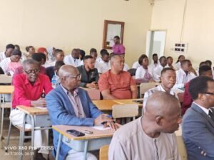 | The Calabash Newspaper Adult students seated at classroom desks listening to a lecture, with a man in a blue blazer foregrounded.
