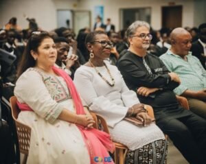 Audience seated at a formal event, diverse individuals watching attentively in a conference hall