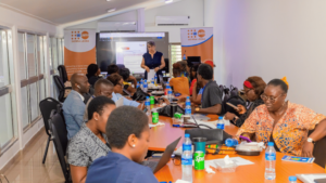 Group of diverse participants in a training session around a long conference table, presenter at the front with UNFPA Sierra Leone banners in the background.