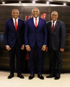 | The Calabash Newspaper Three men in dark suits and red ties posing together indoors, smiling for the camera.