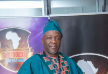Rokel Commercial Bank MD Walton Gilpin Named African Banker of the Year 2026 Man in teal traditional attire holding a certificate at an awards event, backdrop shows Africa map and 'The Voice Achievers Award' banner