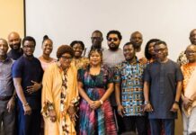 WIMSAL, Partners Intensify Campaign for Safer and More Inclusive Newsrooms Fifteen people posing for a group photo in a conference room, several wearing colorful traditional African attire, with a neutral backdrop.